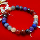 Close-up view of the Divine 7 Chakras Reiki Healing and Protection Bracelet with vibrant gemstones representing each chakra, arranged beautifully on a dark background.