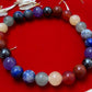 A person wearing the Divine 7 Chakras Bracelet on their wrist, showcasing the colorful gemstones symbolizing each chakra and their alignment.