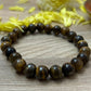Image of Tiger Eye bracelet featuring its polished beads and silver clasp, designed to promote confidence, courage, and emotional balance.